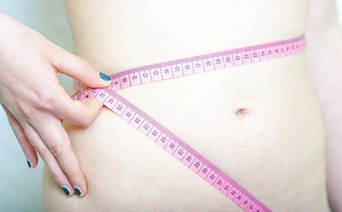 Unha nena mide a cintura para rexistrar os resultados da dieta Dukan